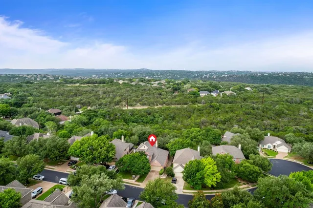 an aerial view of residential houses with outdoor space and trees