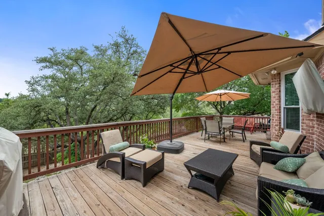 a view of deck with furniture and umbrella