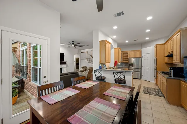 a kitchen with a table chairs refrigerator and cabinets
