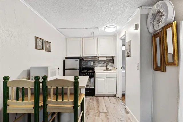 a view of a kitchen with furniture and stainless steel appliances
