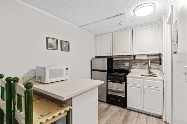 a kitchen with a stove cabinets and a table