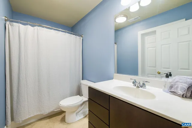 front view of house with a tree and a yard