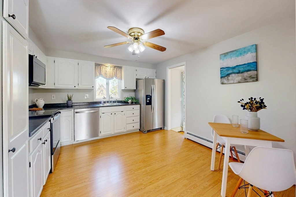 1 Hodge Road Arlington, MA 02474 - Photo 11 of 39 a kitchen with stainless steel appliances a white table chairs and a refrigerator
