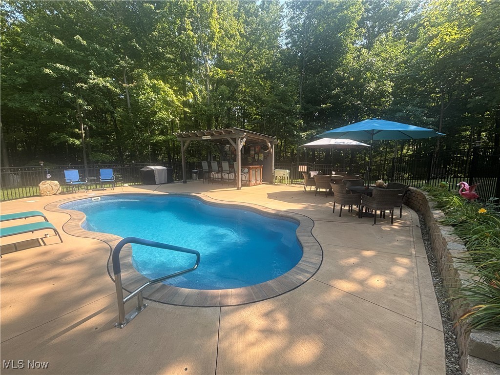 5232 Emerson Road Madison, OH 44057 - Photo 45 of 48 View of swimming pool with a patio, a pergola, and outdoor dining area