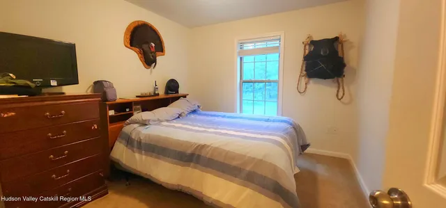a bedroom with a bed and a flat tv screen on dresser