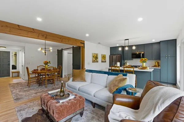 a living room with furniture and a view of kitchen