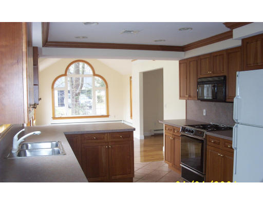 576 Grove Street Framingham, MA 01701 - Photo 4 of 8 a kitchen with a refrigerator a stove a sink and a window