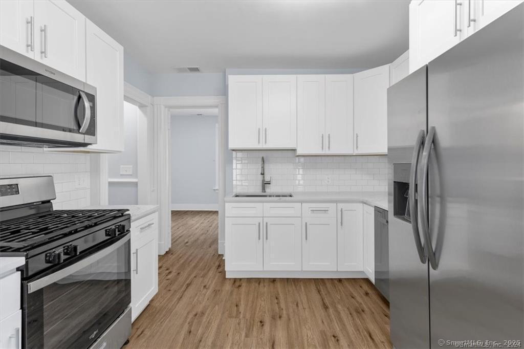 55 Admiral Street, Unit 2 New Haven, CT 06511 - Photo 7 of 35 a kitchen with stainless steel appliances a stove a sink and white cabinets