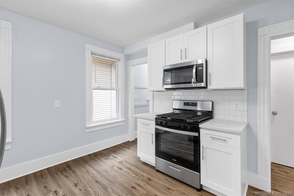 55 Admiral Street, Unit 2 New Haven, CT 06511 - Photo 10 of 35 a kitchen with granite countertop white cabinets and black appliances