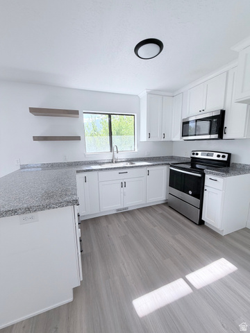 227 South West Lane Provo, UT 84601 - Photo 1 of 25 Kitchen featuring white cabinetry, grey speckled countertops, stainless steel appliances, and wood-finish flooring
