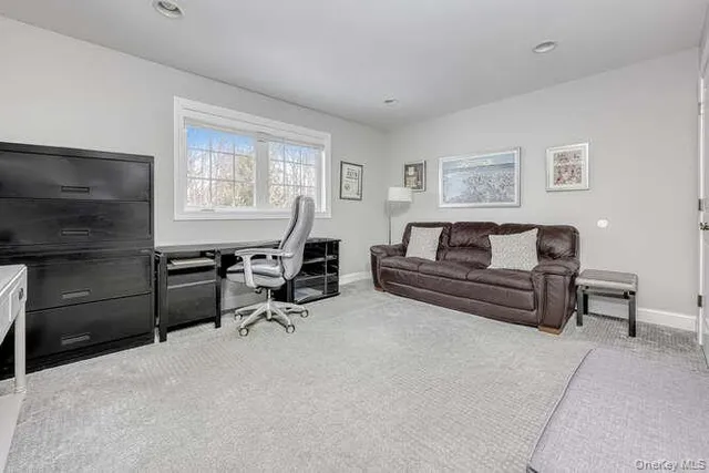 a living room with furniture a flat screen tv and a window
