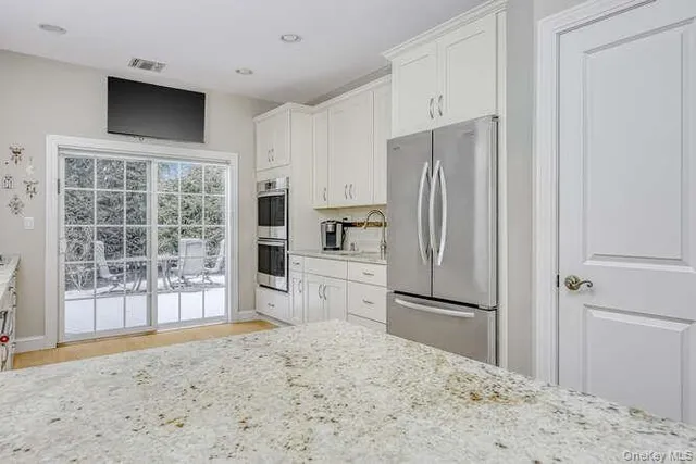 a kitchen with granite countertop a refrigerator and a sink