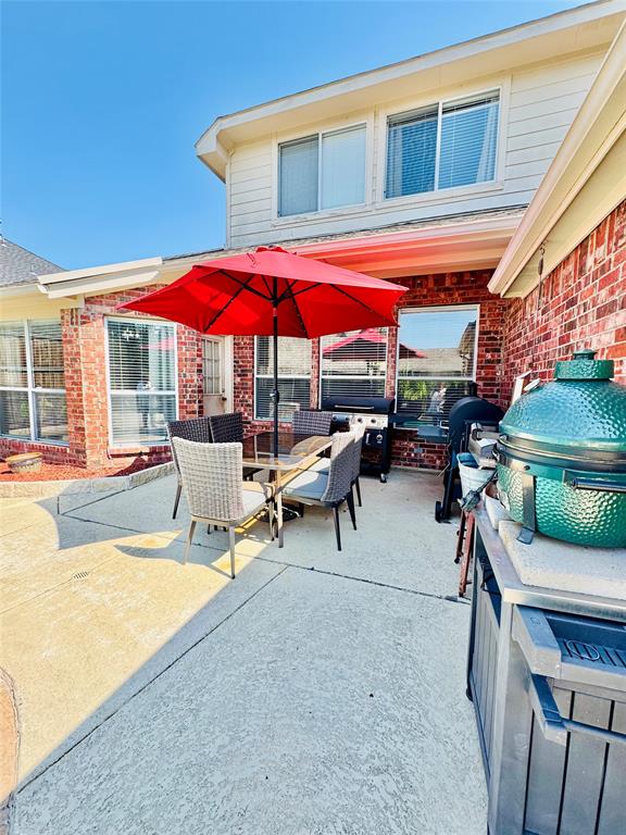 2016 Postwood Court Corinth, TX 76210 - Photo 12 of 39 a view of a patio with a table and chairs under an umbrella