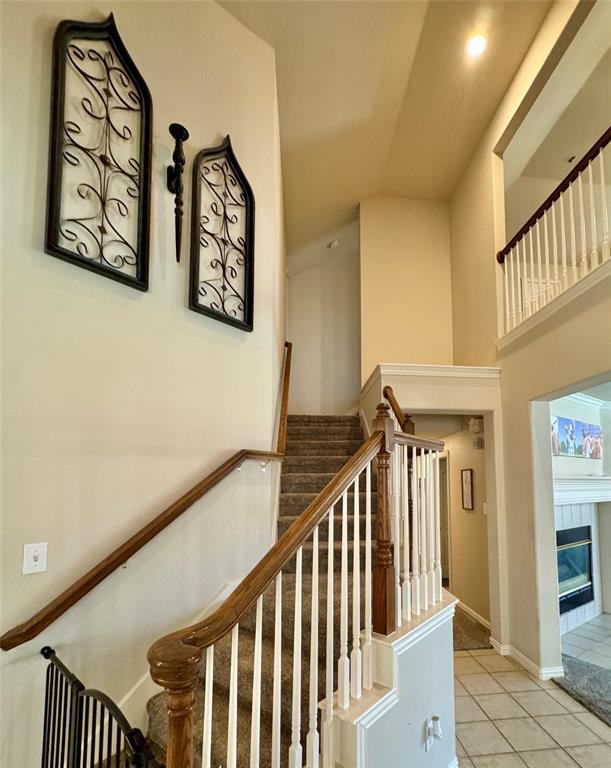 2016 Postwood Court Corinth, TX 76210 - Photo 14 of 39 a view of staircase with lots of frames on wall and a large window