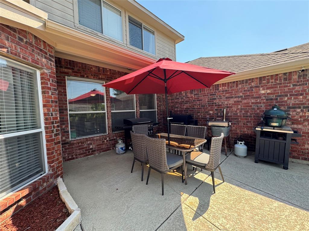 2016 Postwood Court Corinth, TX 76210 - Photo 39 of 39 a patio with a table and chairs under an umbrella