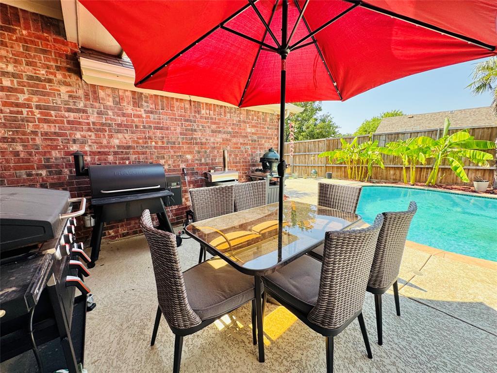 2016 Postwood Court Corinth, TX 76210 - Photo 4 of 39 a view of a patio with a table and chairs under an umbrella