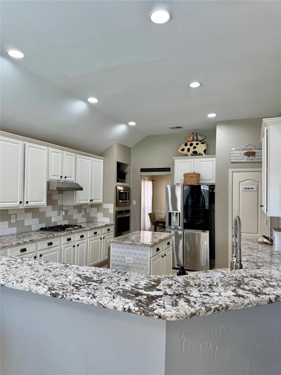 2016 Postwood Court Corinth, TX 76210 - Photo 7 of 39 a kitchen with stainless steel appliances kitchen island granite countertop a stove refrigerator and cabinets