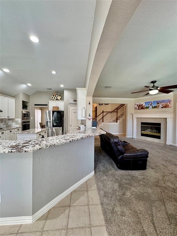 2016 Postwood Court Corinth, TX 76210 - Photo 8 of 39 a kitchen with kitchen island a stove a counter top space and cabinets