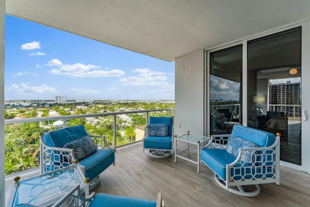 a living room with furniture a floor to ceiling window and a flat screen tv