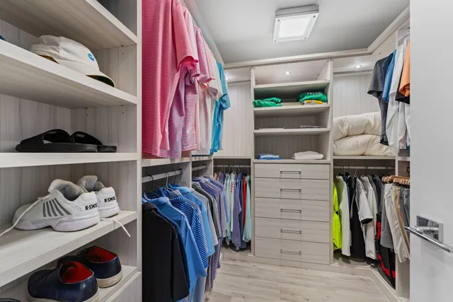 a view of walk in closet with clothes and shoes