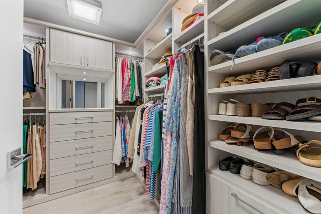 a view of walk in closet with clothes and shoes