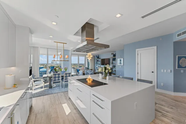 a kitchen with a stove a refrigerator and a dining table with wooden floor