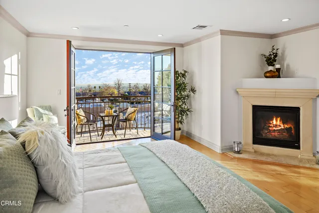 a living room with furniture a fireplace and a floor to ceiling window