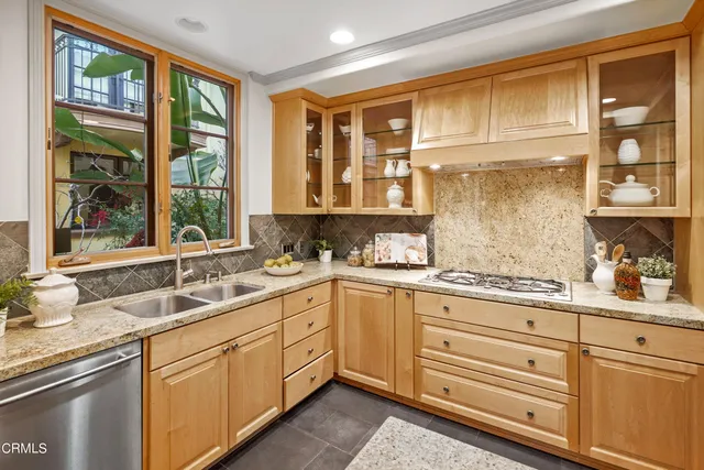 a kitchen with granite countertop stainless steel appliances a sink stove and cabinets