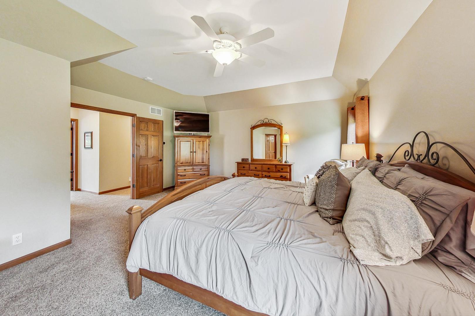 S548 Grengs Lane Geneva, IL 60134 - Photo 20 of 49 a bedroom with a large bed and a chandelier