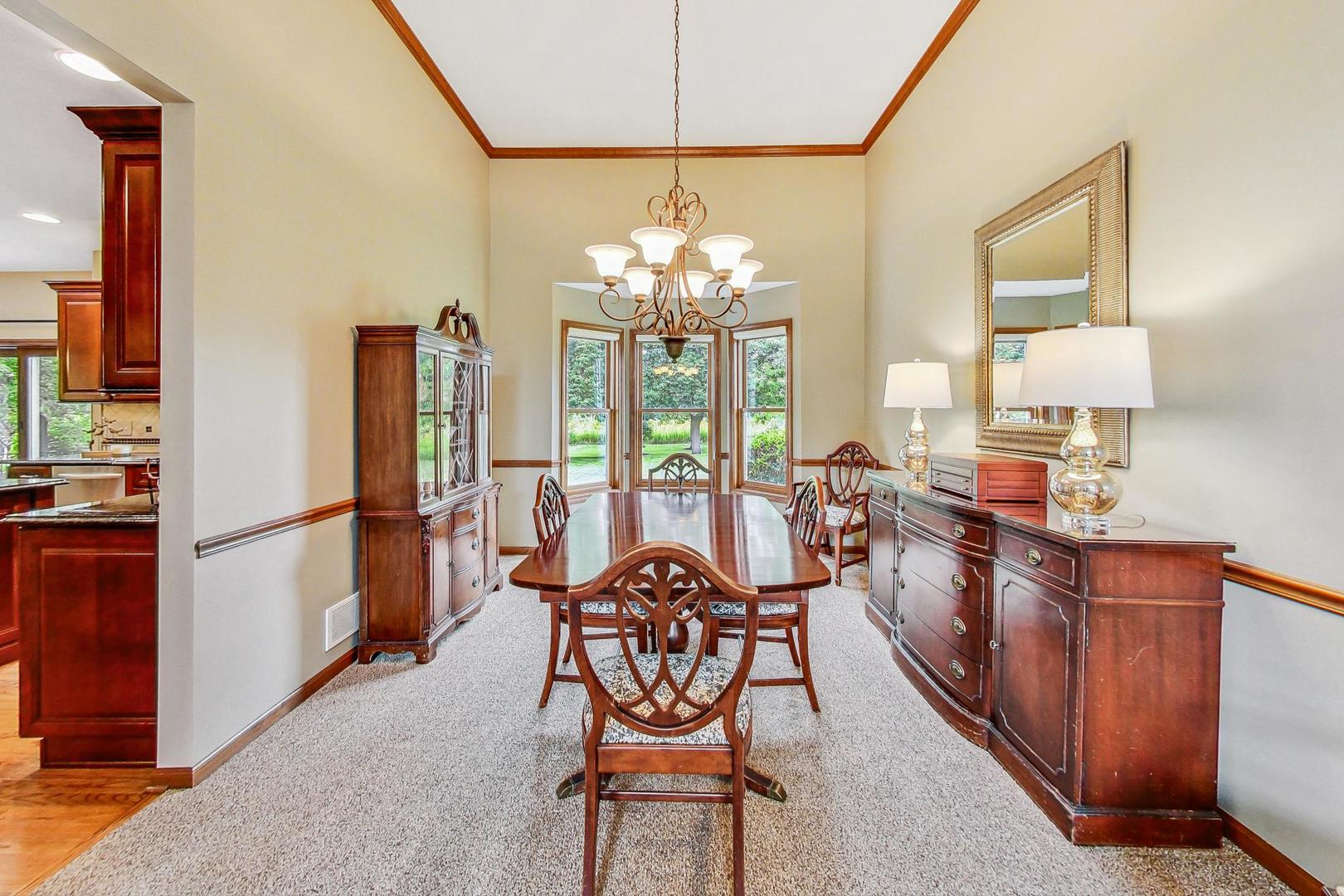 S548 Grengs Lane Geneva, IL 60134 - Photo 9 of 49 a view of a dining room with furniture a chandelier and large windows