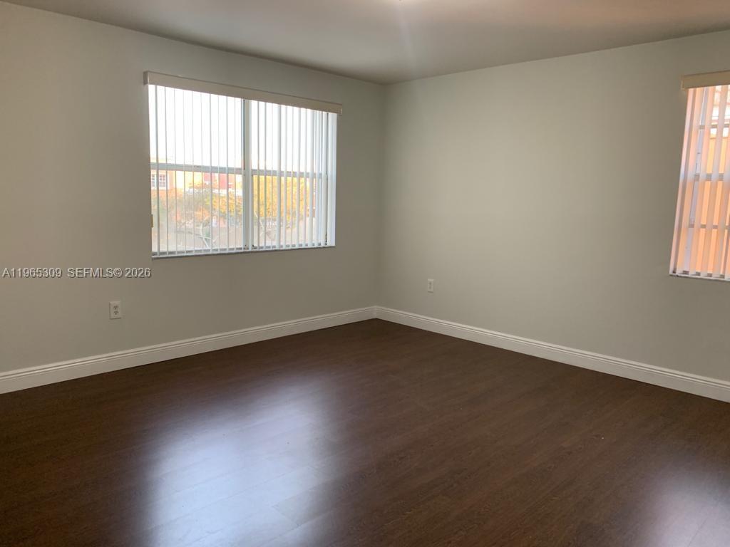 12447 Northwest 7th Street Miami, FL 33172 - Photo 19 of 29 an empty room with wooden floor and windows