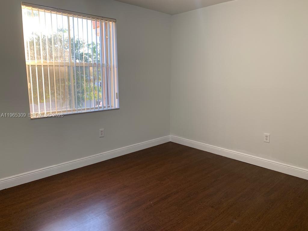 12447 Northwest 7th Street Miami, FL 33172 - Photo 21 of 29 an empty room with wooden floor and windows
