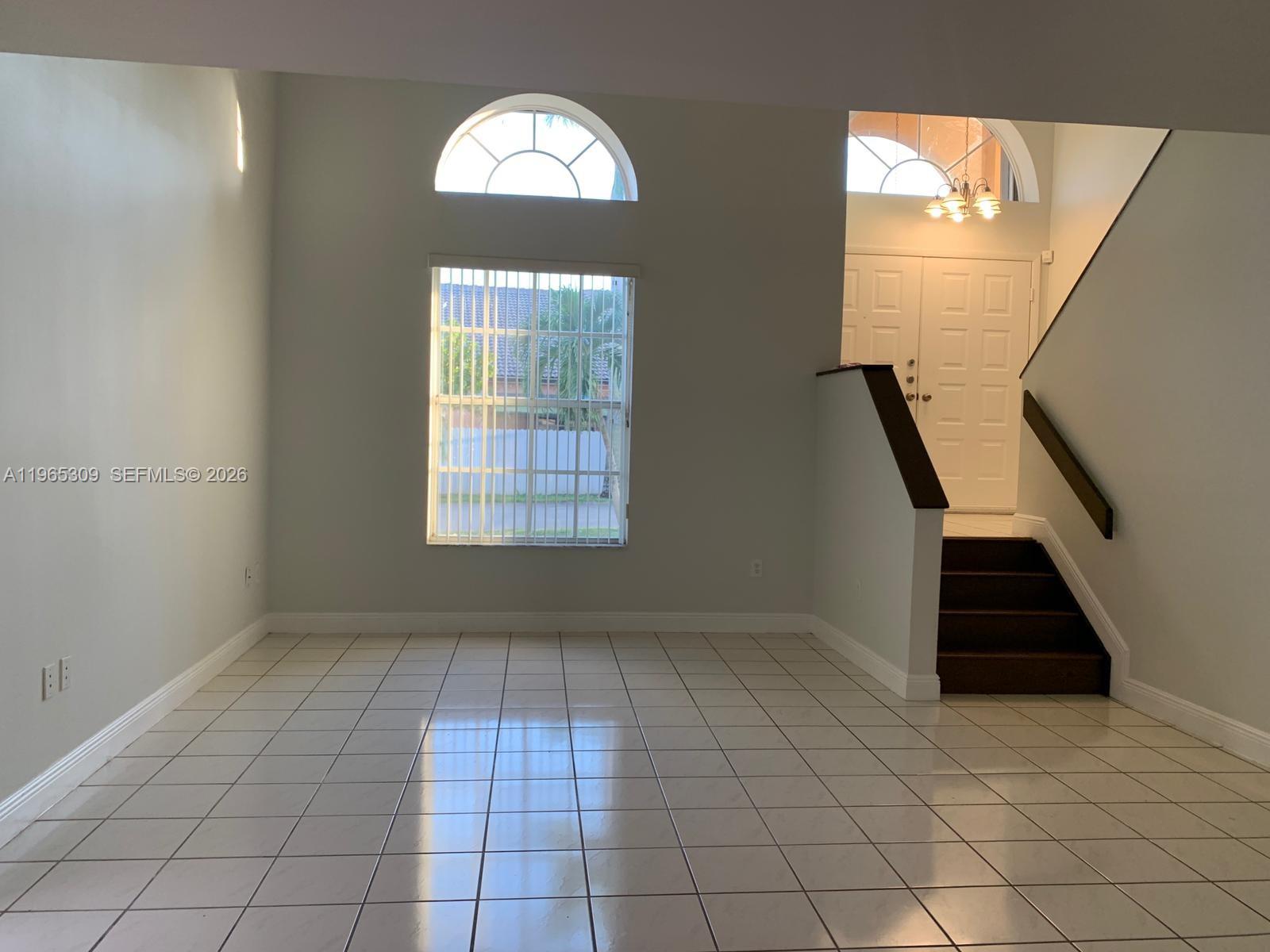 12447 Northwest 7th Street Miami, FL 33172 - Photo 3 of 29 an empty room with windows and stairs