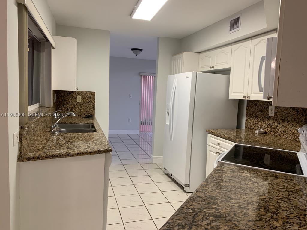 12447 Northwest 7th Street Miami, FL 33172 - Photo 6 of 29 a kitchen with stainless steel appliances granite countertop a refrigerator and a stove
