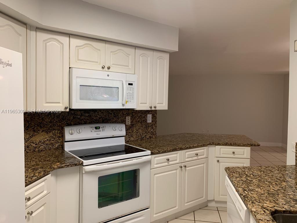 12447 Northwest 7th Street Miami, FL 33172 - Photo 8 of 29 a kitchen with white cabinets and appliances