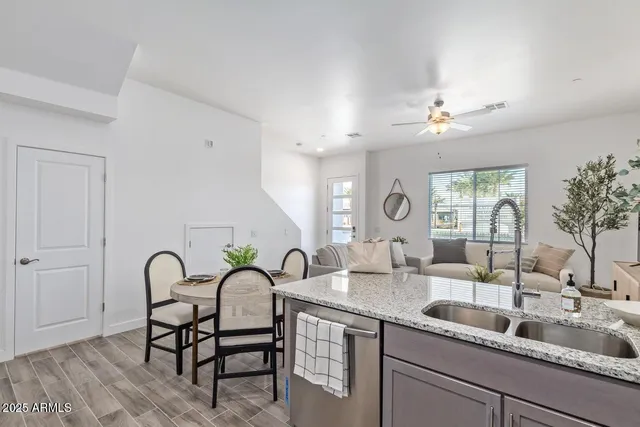 a living room with furniture a chandelier and kitchen view