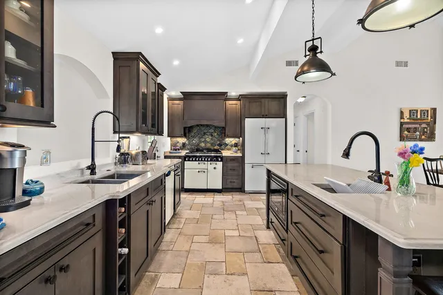 a kitchen with stainless steel appliances granite countertop a sink a stove and cabinets