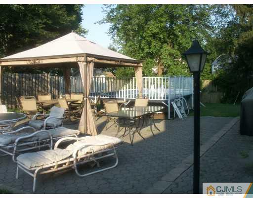 10 Middlesex Road Matawan, NJ 07747 - Photo 8 of 8 a view of a patio with table and chairs potted plants with wooden floor and fence