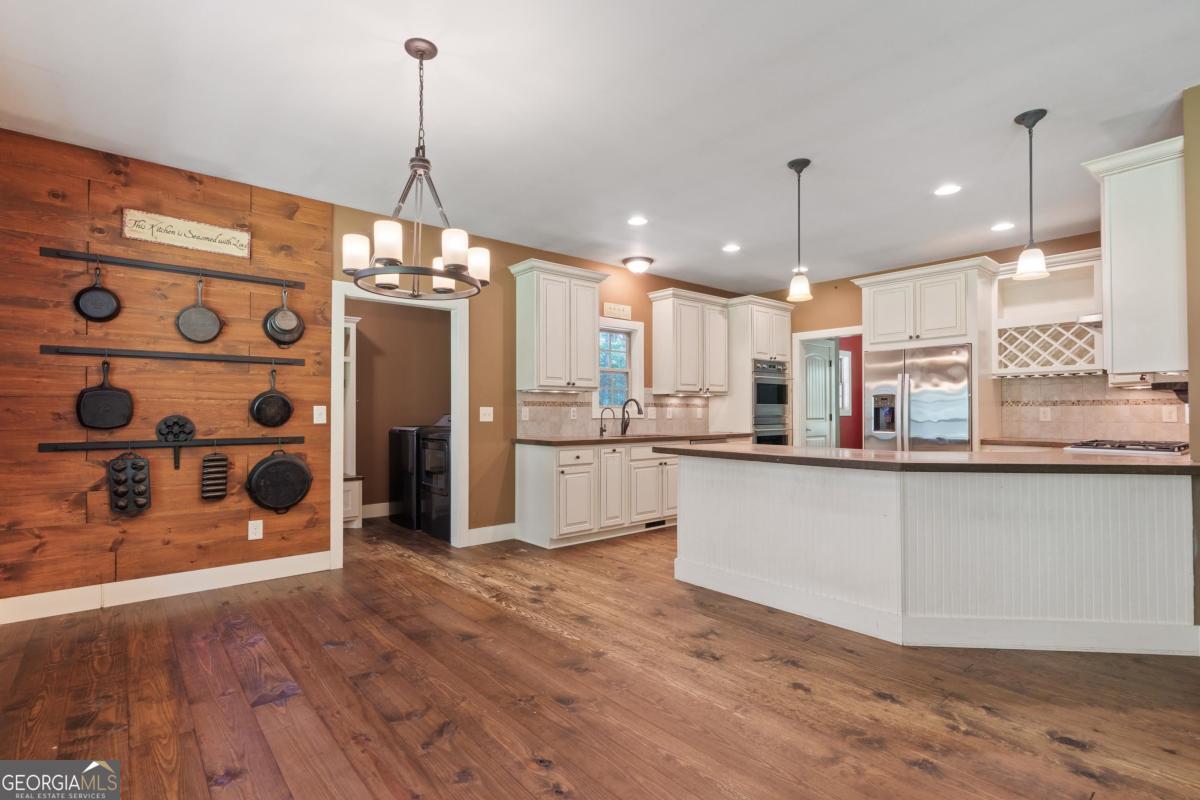 1991 Armour Bridge Road Greensboro, GA 30642 - Photo 19 of 41 a large kitchen with granite countertop a large counter top a refrigerator and cabinets