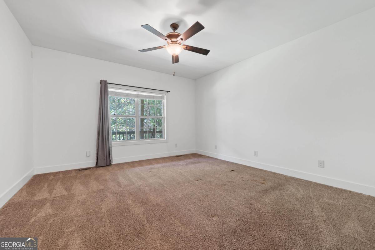 1991 Armour Bridge Road Greensboro, GA 30642 - Photo 25 of 41 an empty room with windows and ceiling fan
