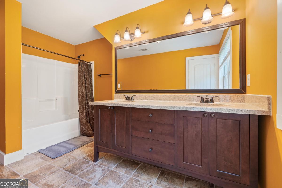 1991 Armour Bridge Road Greensboro, GA 30642 - Photo 35 of 41 a bathroom with a sink a mirror and a bathtub