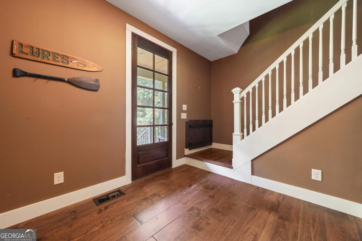 1991 Armour Bridge Road Greensboro, GA 30642 - Photo 8 of 41 a view of an empty room with stairs and wooden floor