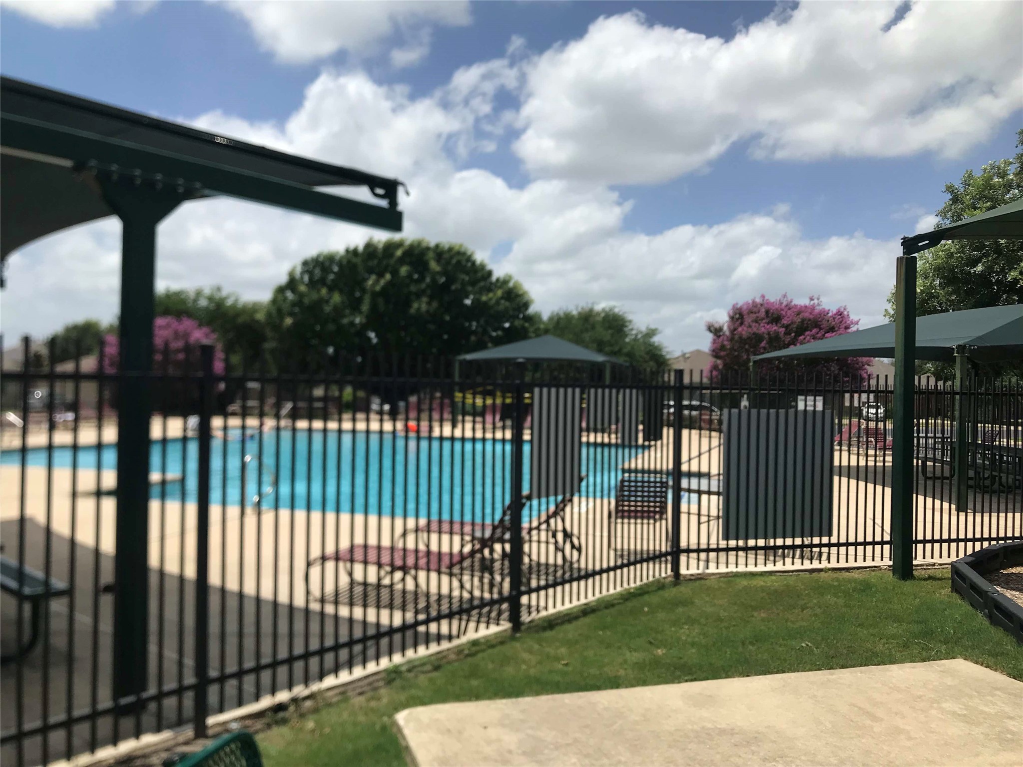913 Rochester Castle Way Pflugerville, TX 78660 - Photo 24 of 25 A community pool invites relaxation with its clear blue water and shaded lounge areas.