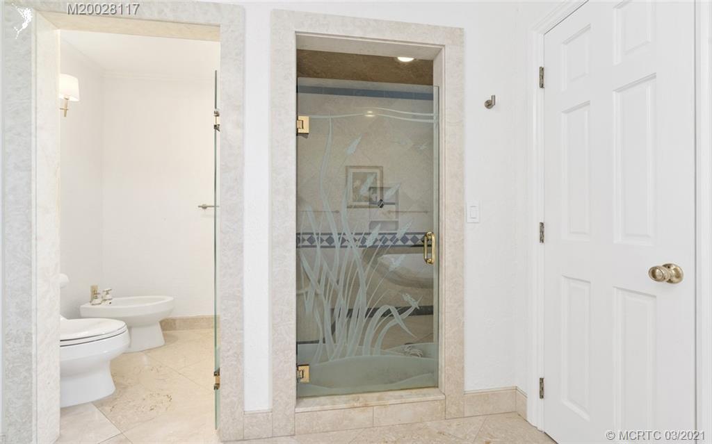 22 East High Point Road Stuart, FL 34996 - Photo 50 of 84 a bathroom with a glass shower door