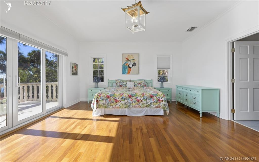 22 East High Point Road Stuart, FL 34996 - Photo 65 of 84 a bedroom with a bed and wooden floor
