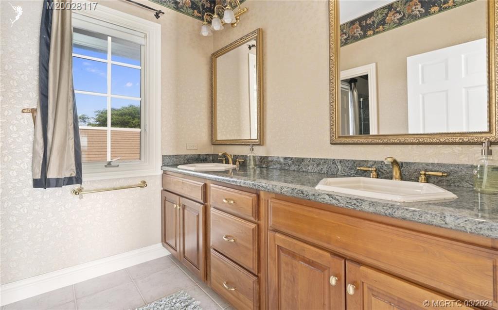 22 East High Point Road Stuart, FL 34996 - Photo 67 of 84 a bathroom with a granite countertop sink and a large mirror