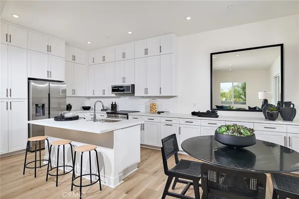 a kitchen with a dining table chairs stove and cabinets