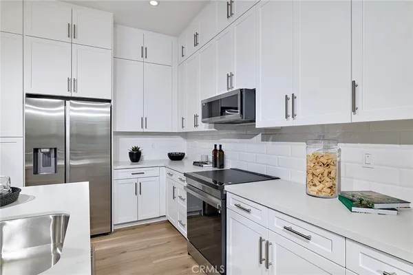 a kitchen with appliances a sink and cabinets