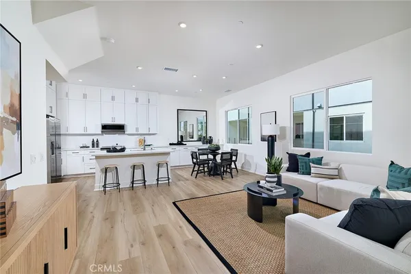 a living room with lots of furniture and kitchen view