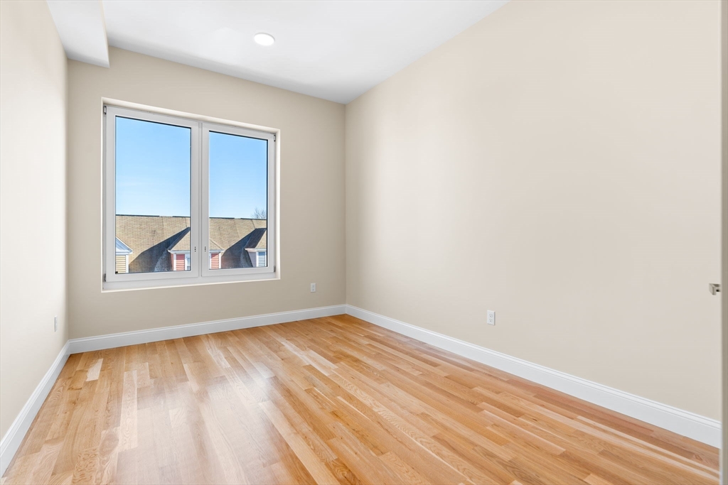 16 Taber Street, Unit 304 Boston, MA 02119 - Photo 6 of 11 a view of an empty room with wooden floor and a window